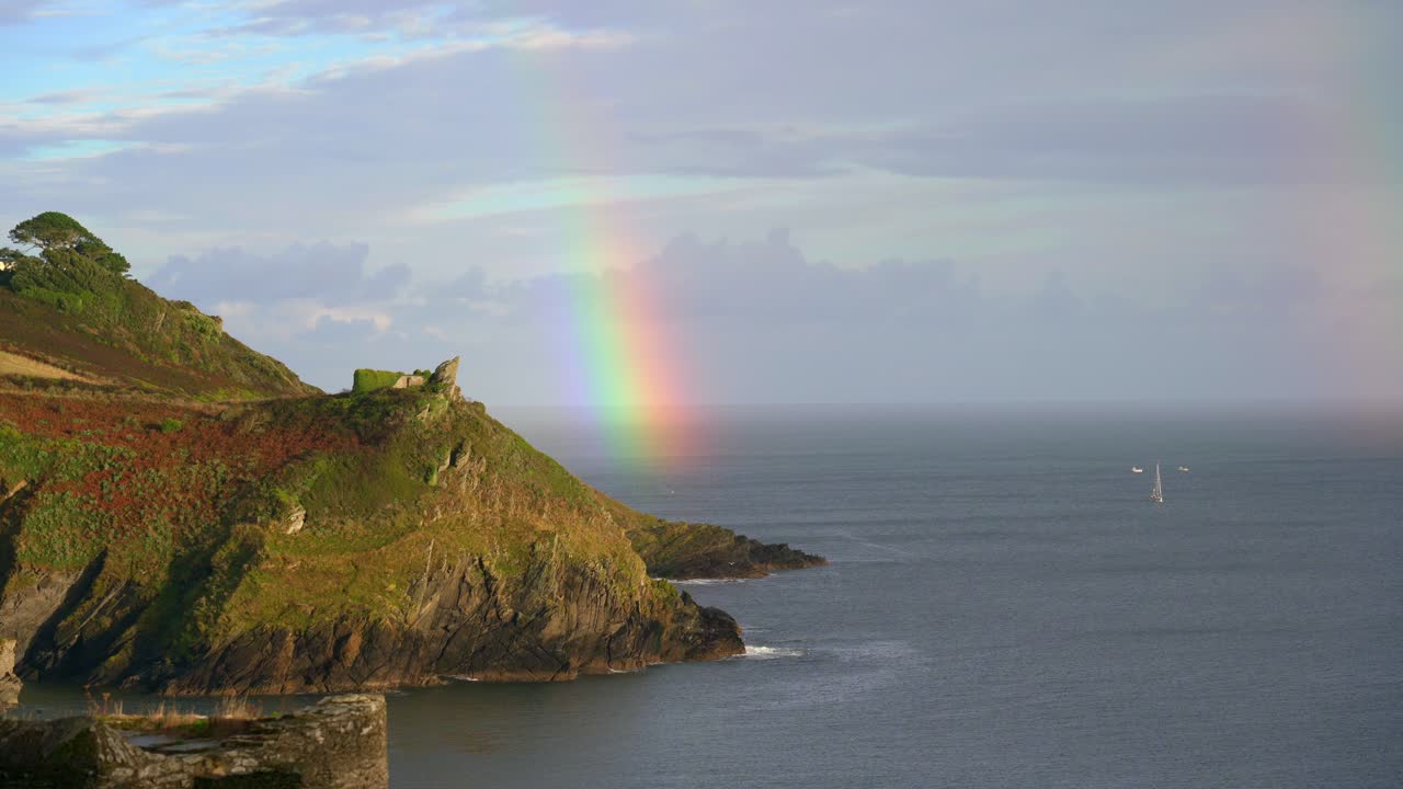 arco iris en la costa de un promontorio en polruan en cornualles