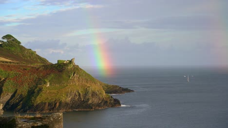 coast rainbow over a headland in polruan in cornwall