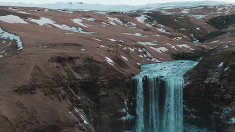 impresionante fotografía de un avión no tripulado de la cascada de skagafoss en islandia, que muestra la caída del agua y un impresionante paisaje nevado