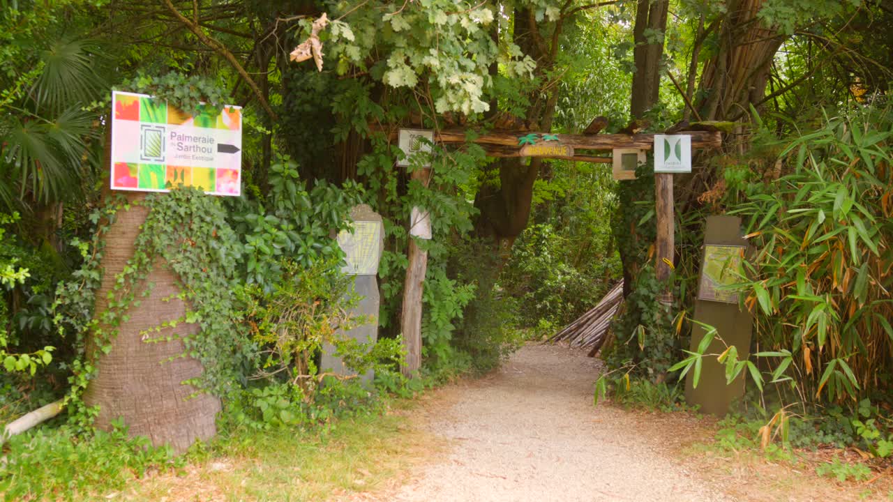 Entrance to lush exotic garden in Bétou, France, serene and inviting