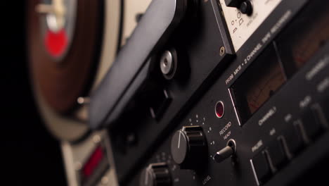 starting playback of reel-to-reel audio tape on professional magnetophone, close up