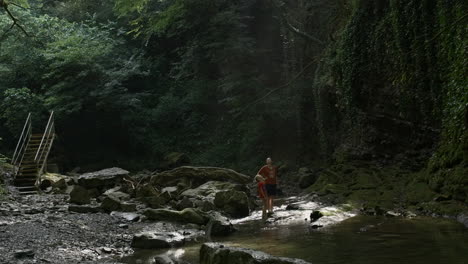 familia de senderismo en un arroyo del bosque