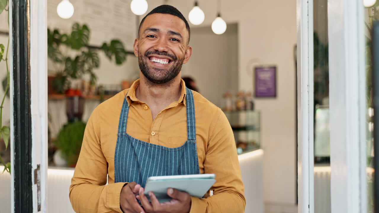 A smiling cafe owner using a tablet
