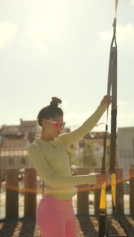 mujer trabajando con entrenador de suspensión al aire libre