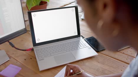 African-american-casual-businesswoman-using-laptop-with-copy-space-in-office,-slow-motion