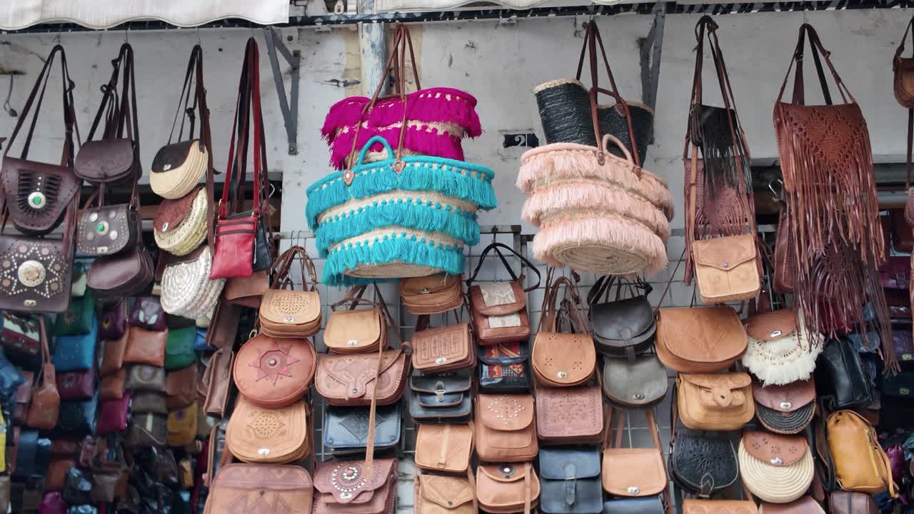 Colorful handmade leather and woven bags hanging in a marketplace in Morocco