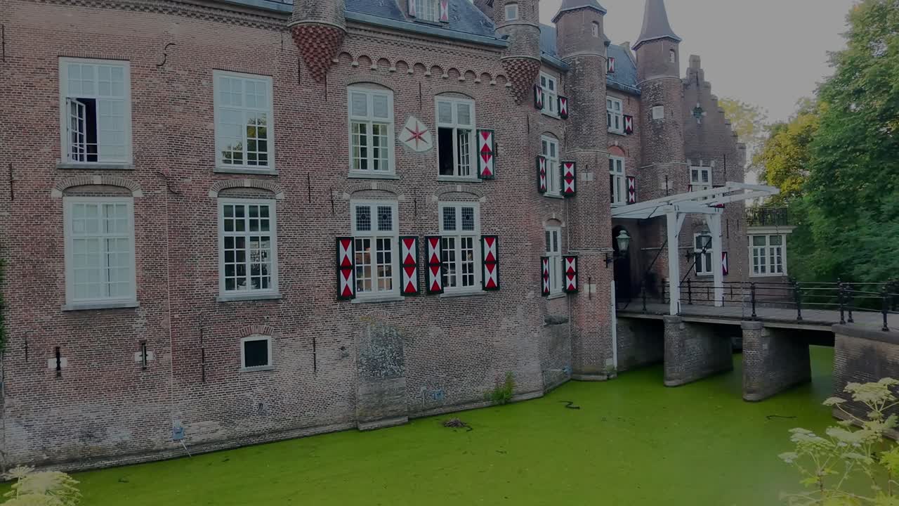 Luchtfoto van het Nederlandse middeleeuwse kasteel Maurick in Vught. Met een ophaalbrug over het kanaal. Camerabeweging (drone) omhoog en naar rechts
