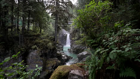mamquam falls flowing in the river from a distance in squamish, bc, canada