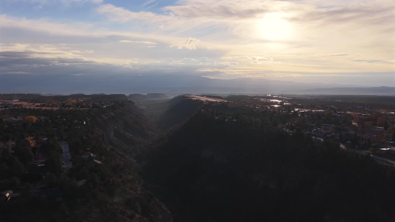 Drone continues pushing into the deepest section of the canyon gorge. Massive rock walls emphasize the sheer vertical expanse illuminated by soft sunrise light
