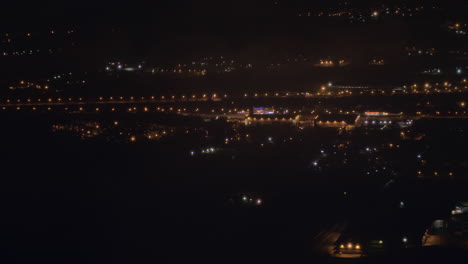 Blick-Aus-Dem-Flugzeug,-Das-über-Die-Nächtliche-Stadt-Fliegt