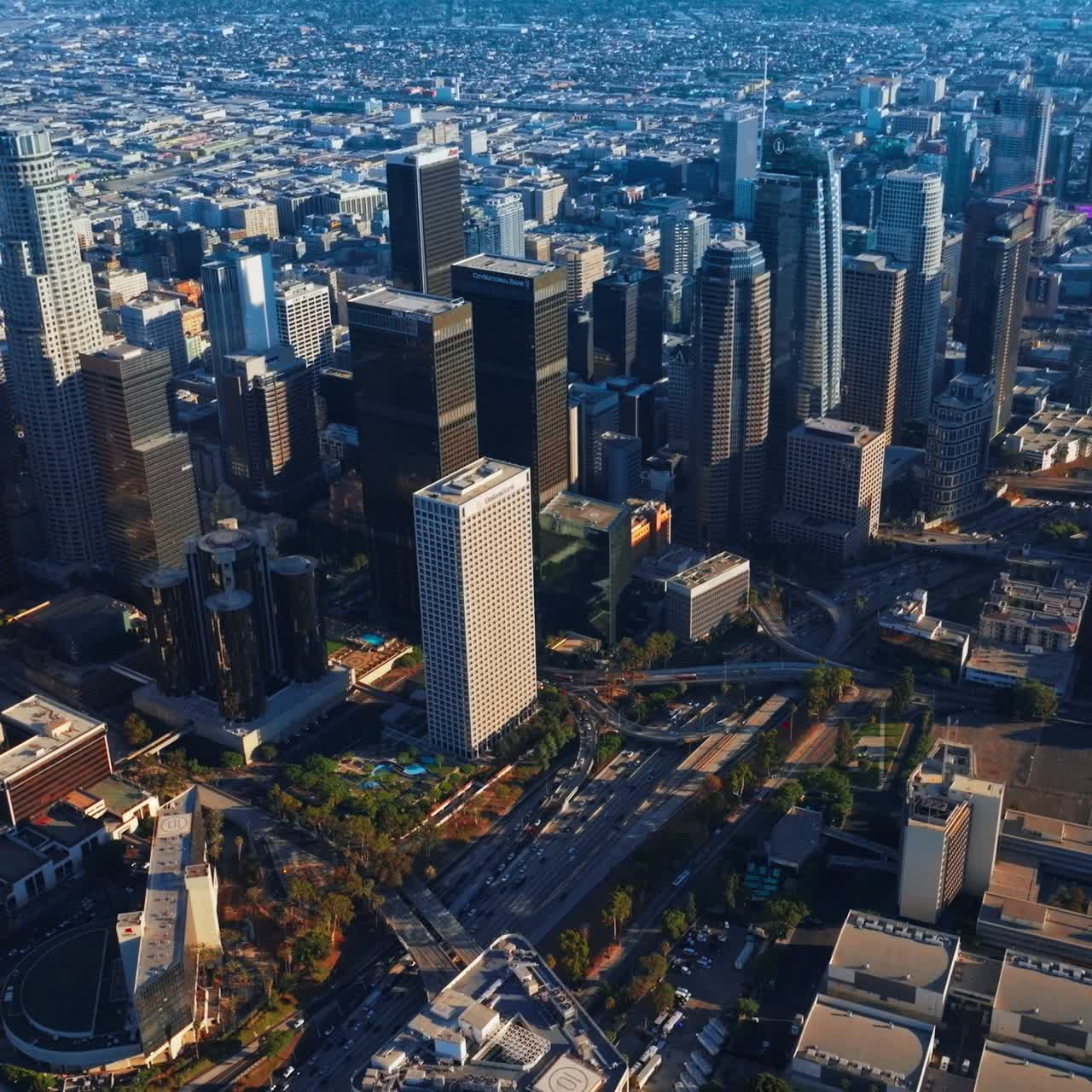 Majestic skyscrapers towering over the financial downtown. Lively traffic through the city center of Los Angeles at daytime. Top view