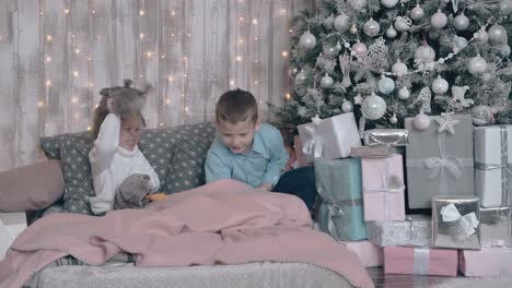 adorable siblings play hide and seek with toys on cozy bed