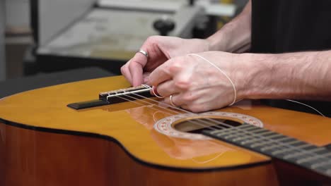 caucasian luthier threads string on spanish guitar