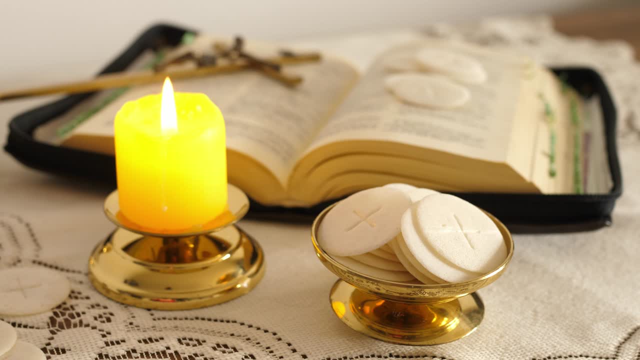 las hostias de la comunión encendieron una vela y la santa biblia cruz con jesús