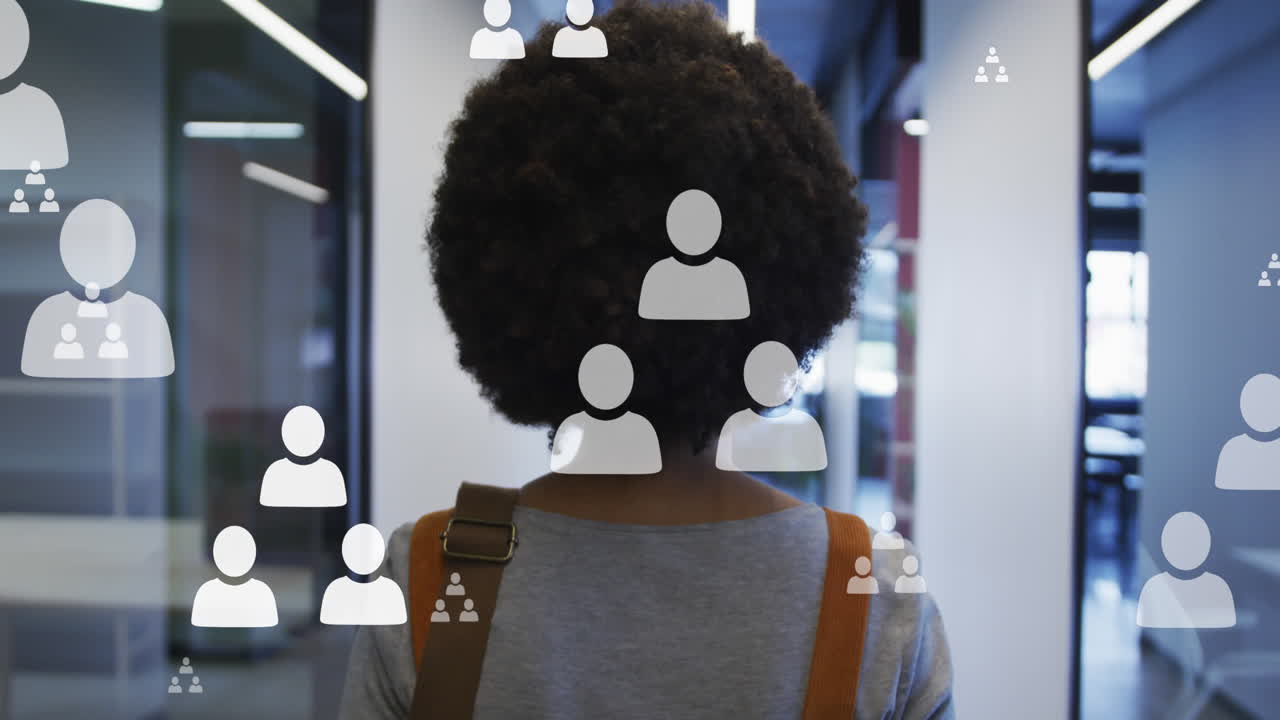 animación de iconos de los medios sobre una mujer de negocios afroamericana caminando en la oficina