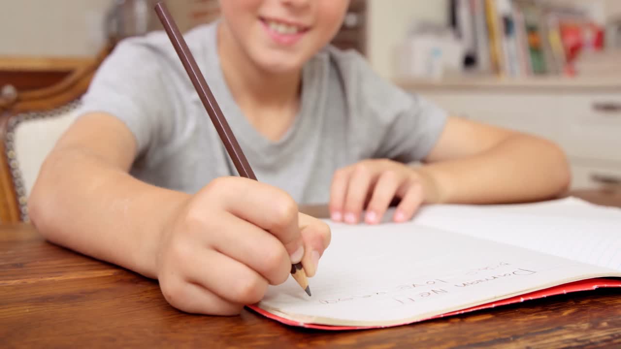 niño sonriente escribiendo en un cuaderno