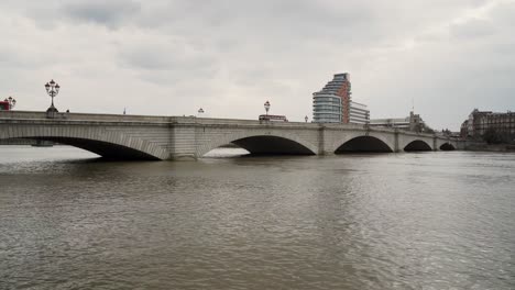 Pequeño-Puente-Con-Tráfico-Lento-Sobre-Un-Río-Perezoso