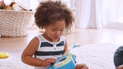 Young-black-girl-playing-ukulele-and-singing-with-her-dad