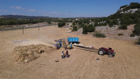 agricultores cortando heno con un tractor