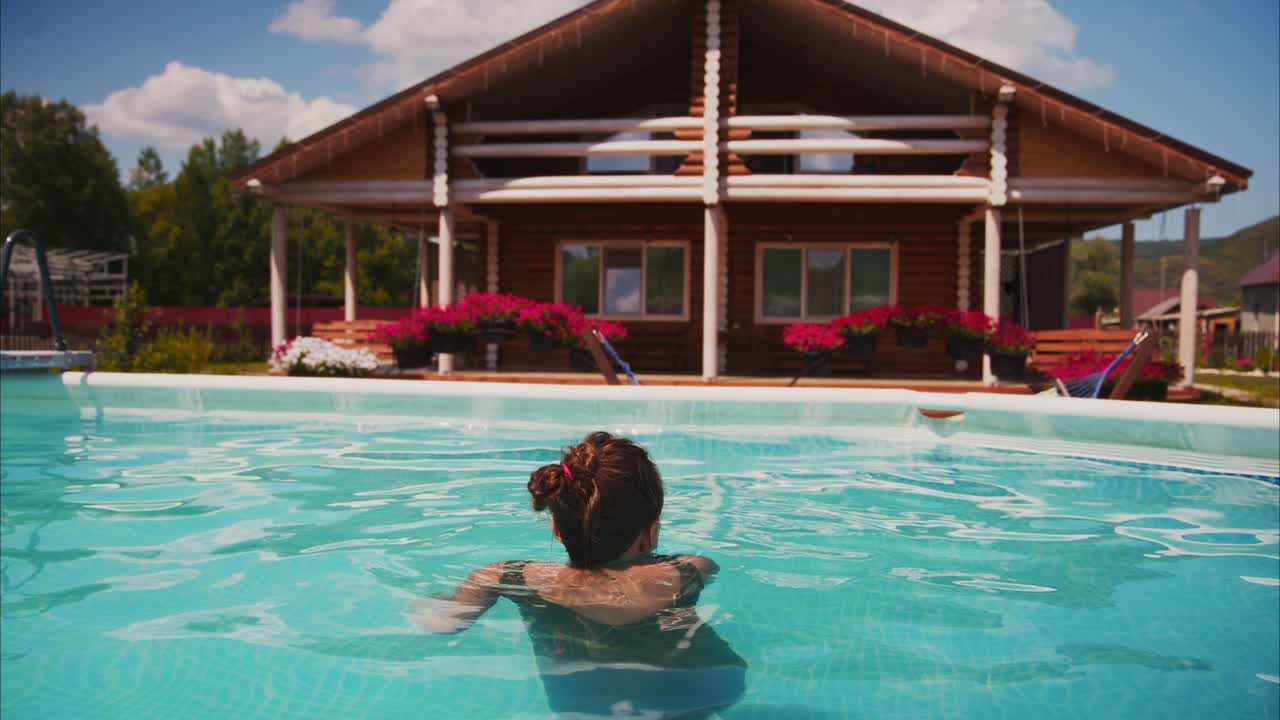 Mulher relaxando e nadando em uma piscina ao ar livre em um dia ensolarado.