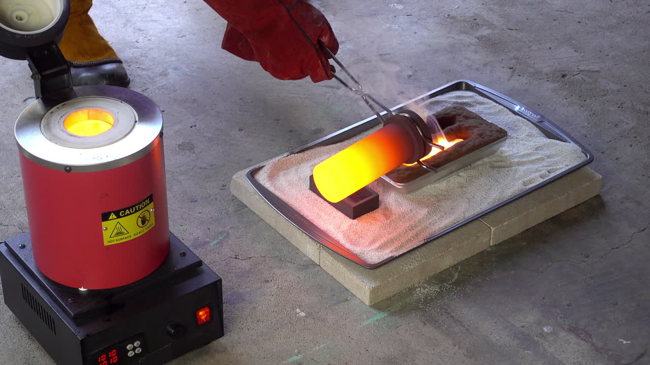 Yellow-hot crucible is removed from furnace and molten brass poured into molds