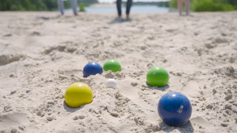 vista cercana de algunas bolas de petanca coloridas en la playa en un día soleado