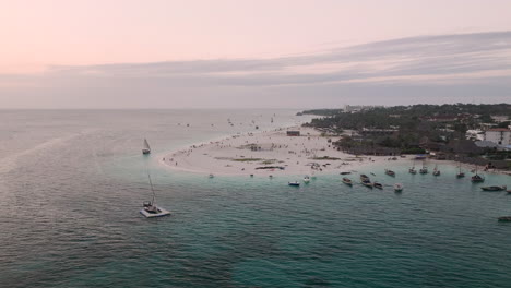 panorama de la costa al atardecer, vista desde un avión no tripulado de la playa de arena, el océano turquesa, la palmera, el complejo de lujo y la gente, zanzíbar, tanzania