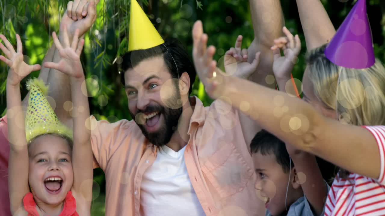 animación de bokeh sobre feliz familia caucásica en sombreros de cumpleaños celebrando juntos