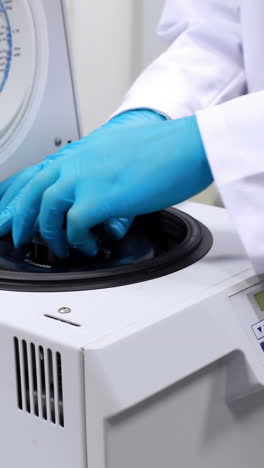 chemist using centrifuge in the lab