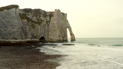 Punto-De-Referencia-De-La-Puerta-Durdle-En-Inglaterra,-Filmado-Con-Un-Dron-En-Un-Día-Soleado-Mientras-El-Sol-Se-Pone