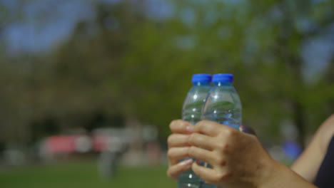 Manos-Femeninas-Entrenando-Con-Botellas-De-Agua