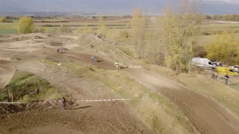 toma aérea siguiendo a los pilotos de motocross en la pista de carreras