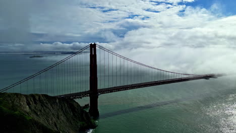 clouds flowing on golden gate bridge in san francisco, california, usa, aerial view