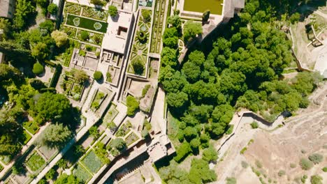 Toma-Aérea-De-Drones-Inclinados-Hacia-Arriba-Del-Castillo-De-La-Alhambra-Con-Los-Jardines,-La-Ciudad-Y-El-Horizonte,-Granada,-España,-4k