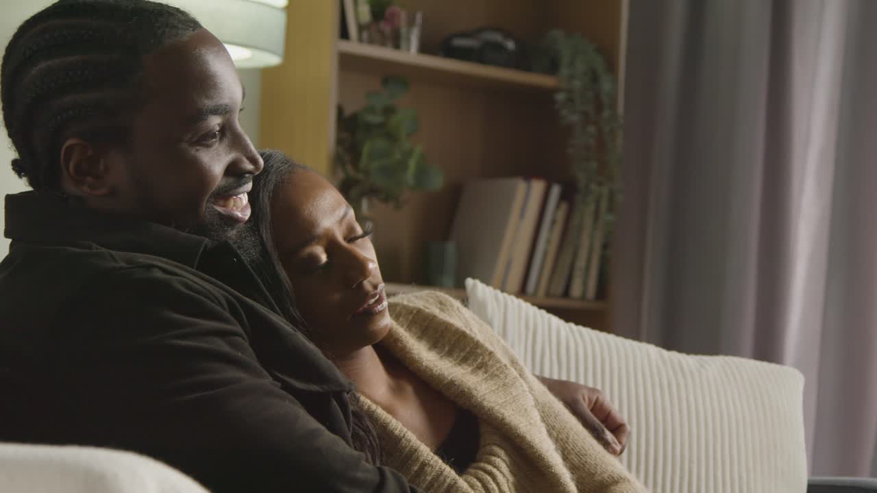 Couple At Home Sitting On Sofa In Lounge With Man Comforting Unhappy Woman 1
