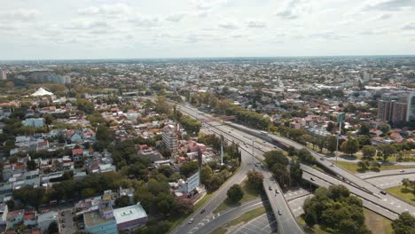 aerial view of trees, houses and transit on general paz avenue at buenos aires city