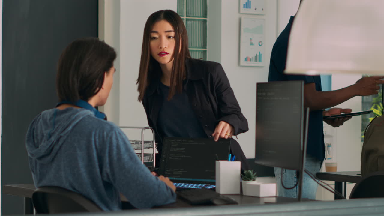 Team of database admins analyzing source code on computer monitor