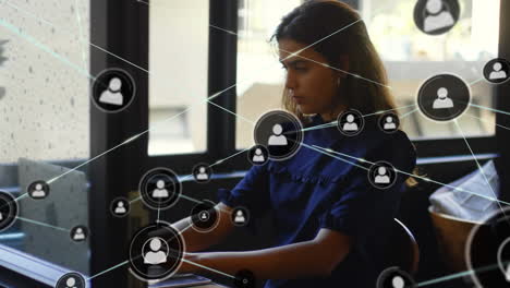 animación de una red de conexiones con iconos sobre una mujer de negocios usando una computadora portátil