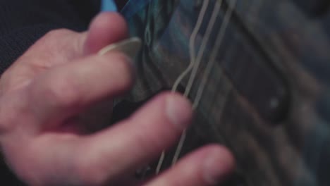 primer plano de una persona tocando una guitarra eléctrica