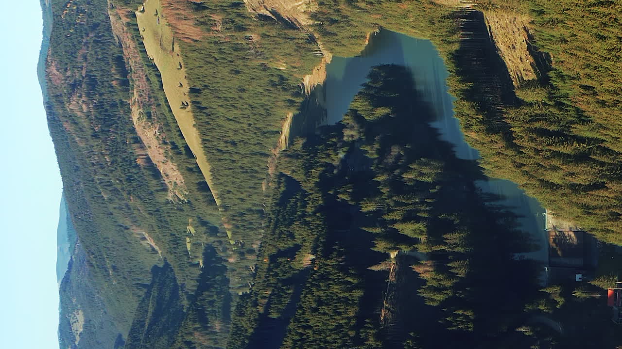 video vertical aéreo del río olt corriendo a través de las montañas hasmas rumania