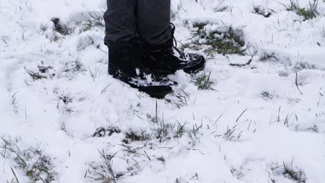 一個人用靴子在白色的冬天風景上射擊雪球的慢動作拍攝