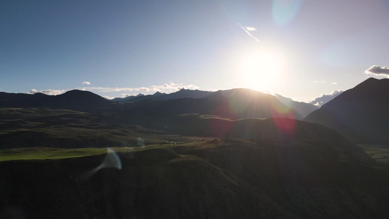 Aerial wide shot of beautiful sunset rays behind Sacred Valley Mountains in Cusco, Peru - picturesque  nature panorama view