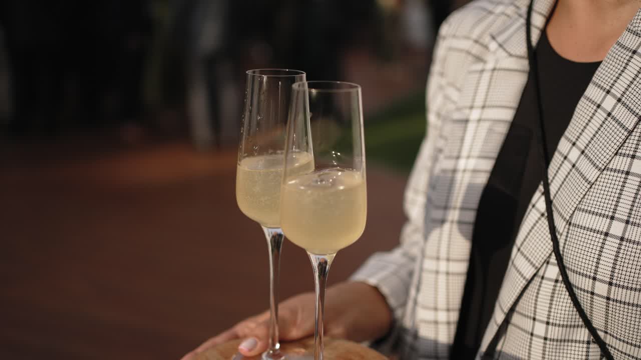 Close up of two champagne flutes filled with sparkling wine at an event
