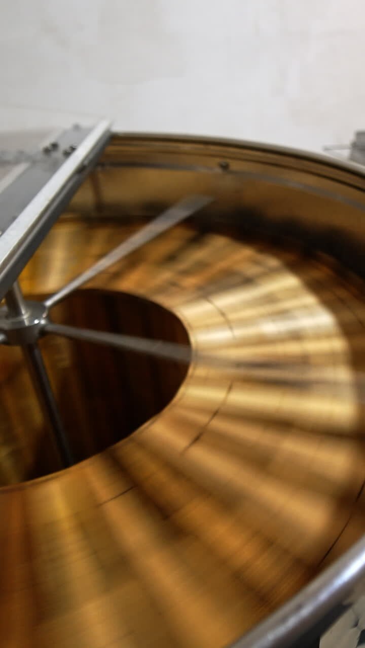 Rotating mechanism working in the centrifuge machine at apiary. Metal box full of frames standing beside. Process of organic honey extraction. Vertical video