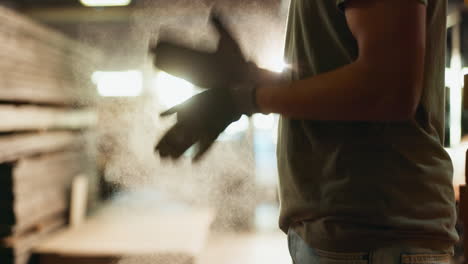 a man walking in a dusty woodshop with a forklift