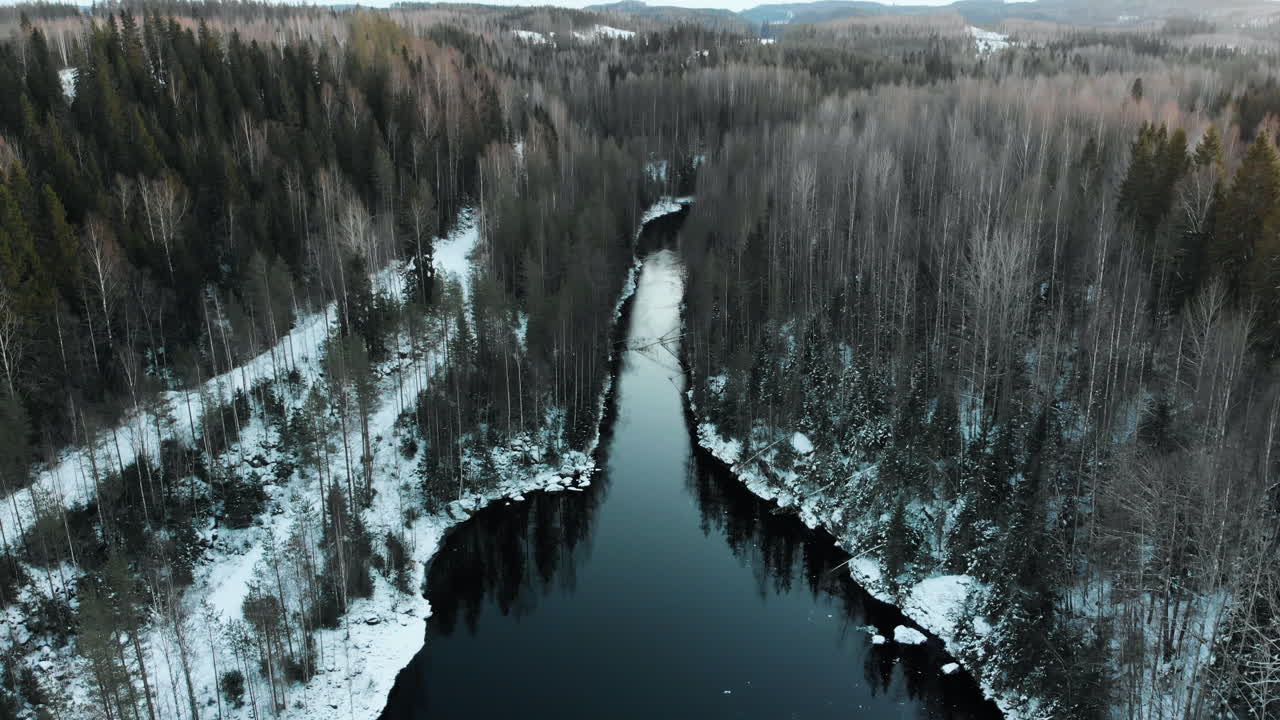 aéreo, descendente, inclinado hacia abajo, disparo de dron, sobre un río, en un bosque sin hojas, primera nevada en el suelo, cerca de joensuu, karelia del norte, finlandia