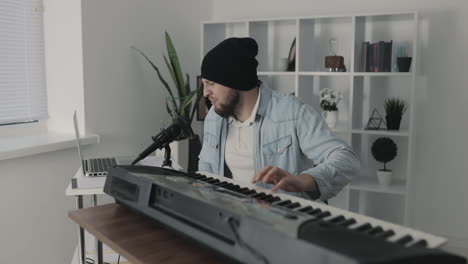 male musician singing and playing electric keyboard at home