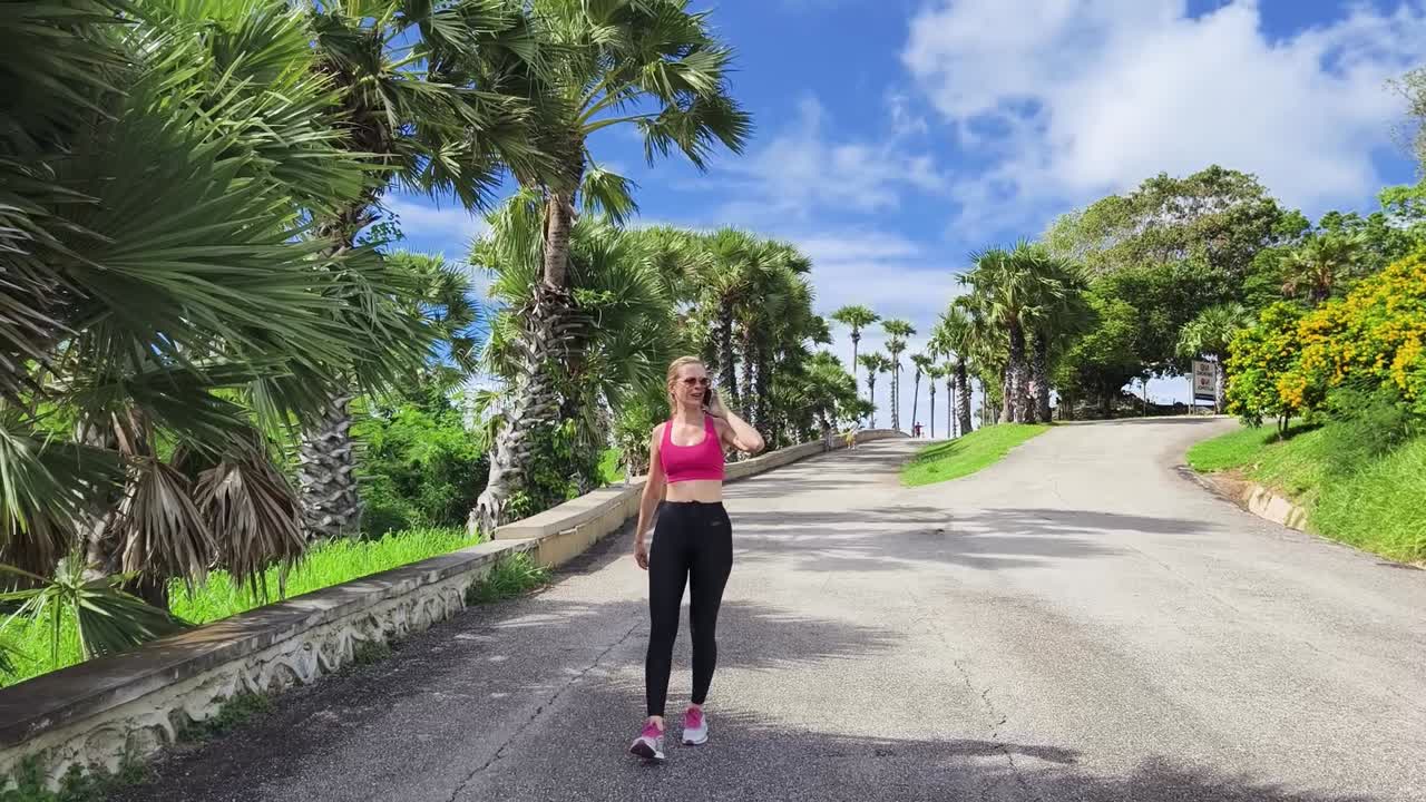 mujer caminando por un camino tropical