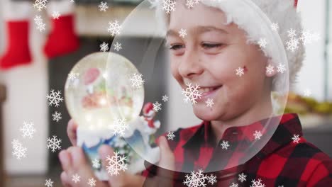 Animation-of-snow-falling-at-chrsitmas-over-happy-caucasian-boy-with-snow-globe
