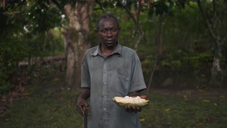 black african local man holding a cocoa fruit in his hand in a cinematic slow motion